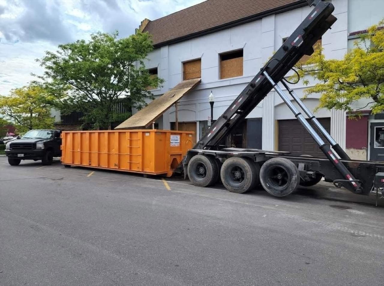All In Dumpster Rentals roll-off truck delivering a dumpster on a Southeast Michigan jobsite