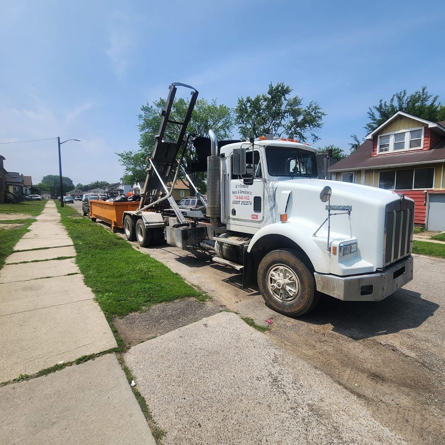 All In Dumpster Rentals roll-off truck dropping a dumpster in a Wayne County neighborhood